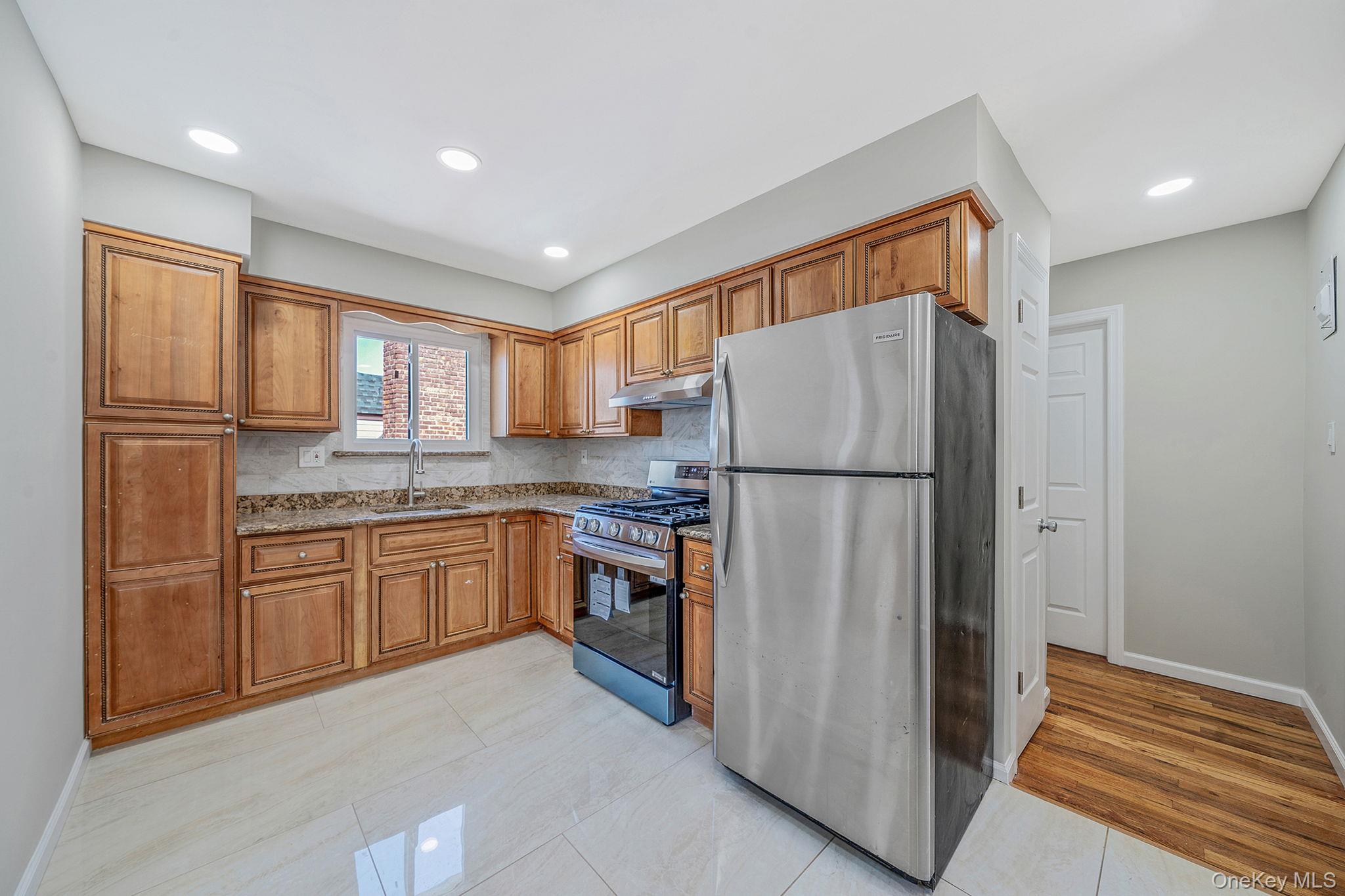220-53 137th Road Queens, NY 11413 - Photo 20 of 41 a kitchen with stainless steel appliances granite countertop a refrigerator and a sink