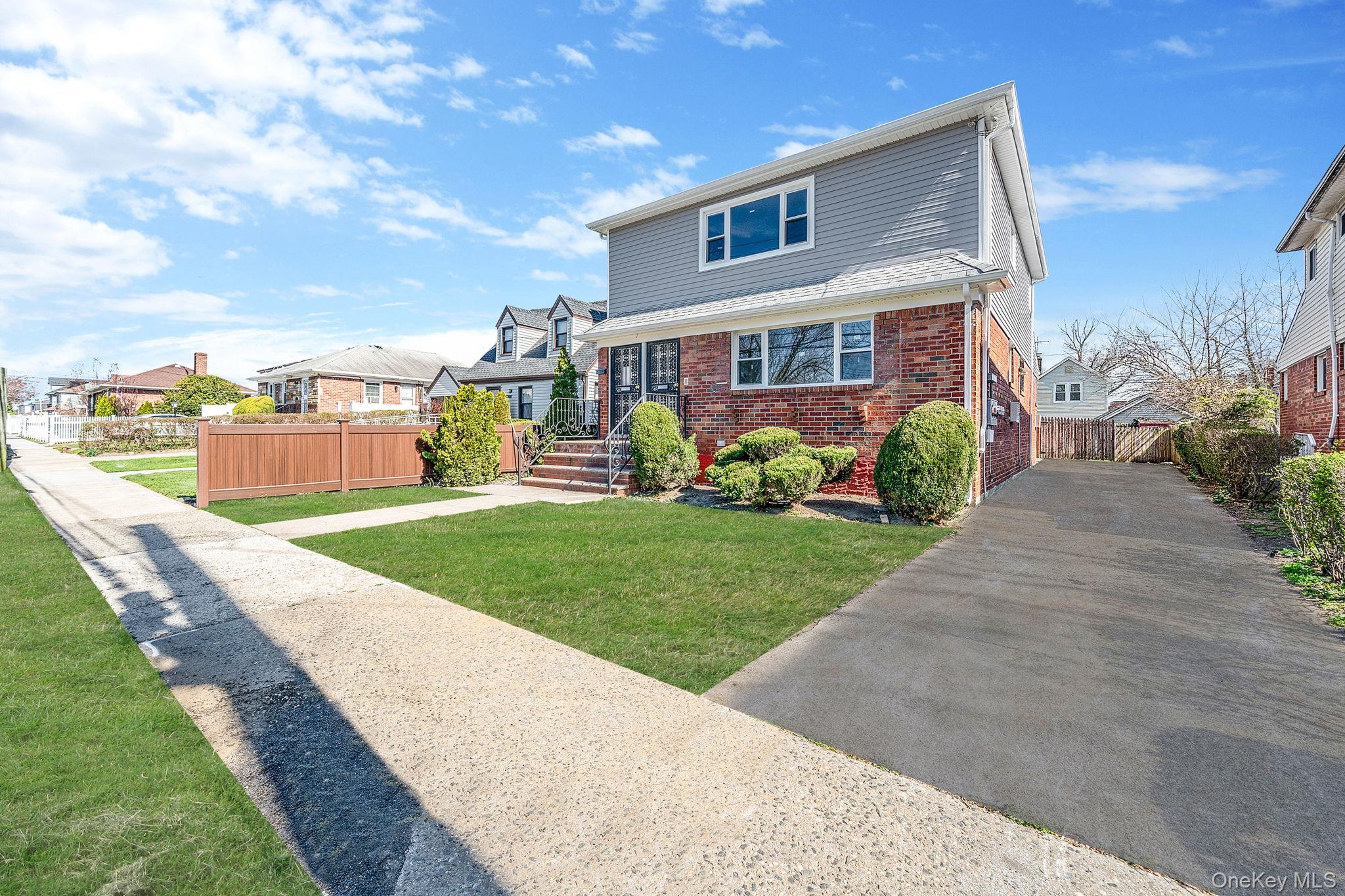 220-53 137th Road Queens, NY 11413 - Photo 2 of 41 a front view of a house with a yard