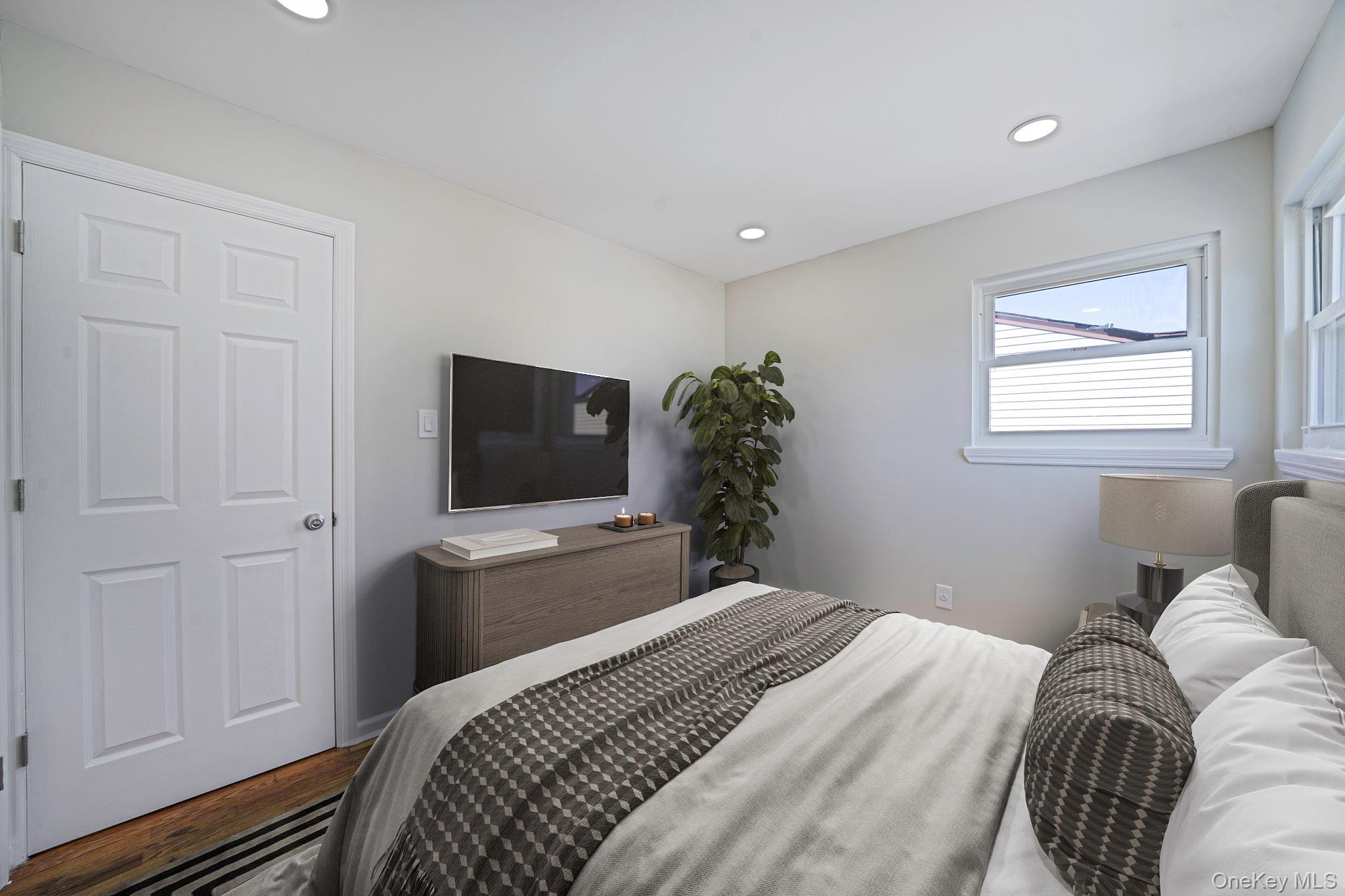 220-53 137th Road Queens, NY 11413 - Photo 25 of 41 a bedroom with a bed and a flat screen tv