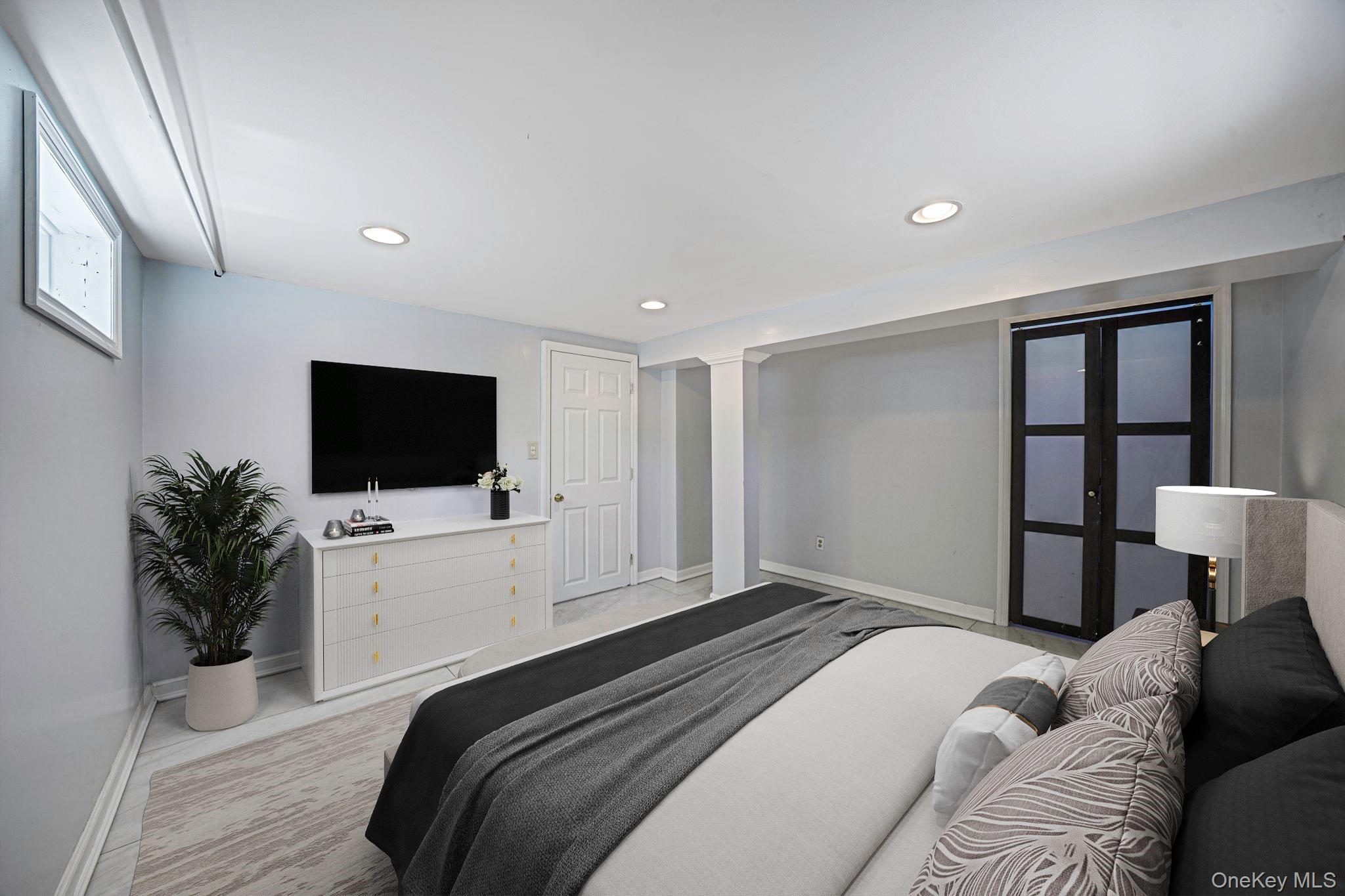 220-53 137th Road Queens, NY 11413 - Photo 30 of 41 a bedroom with a bed a television and a couch