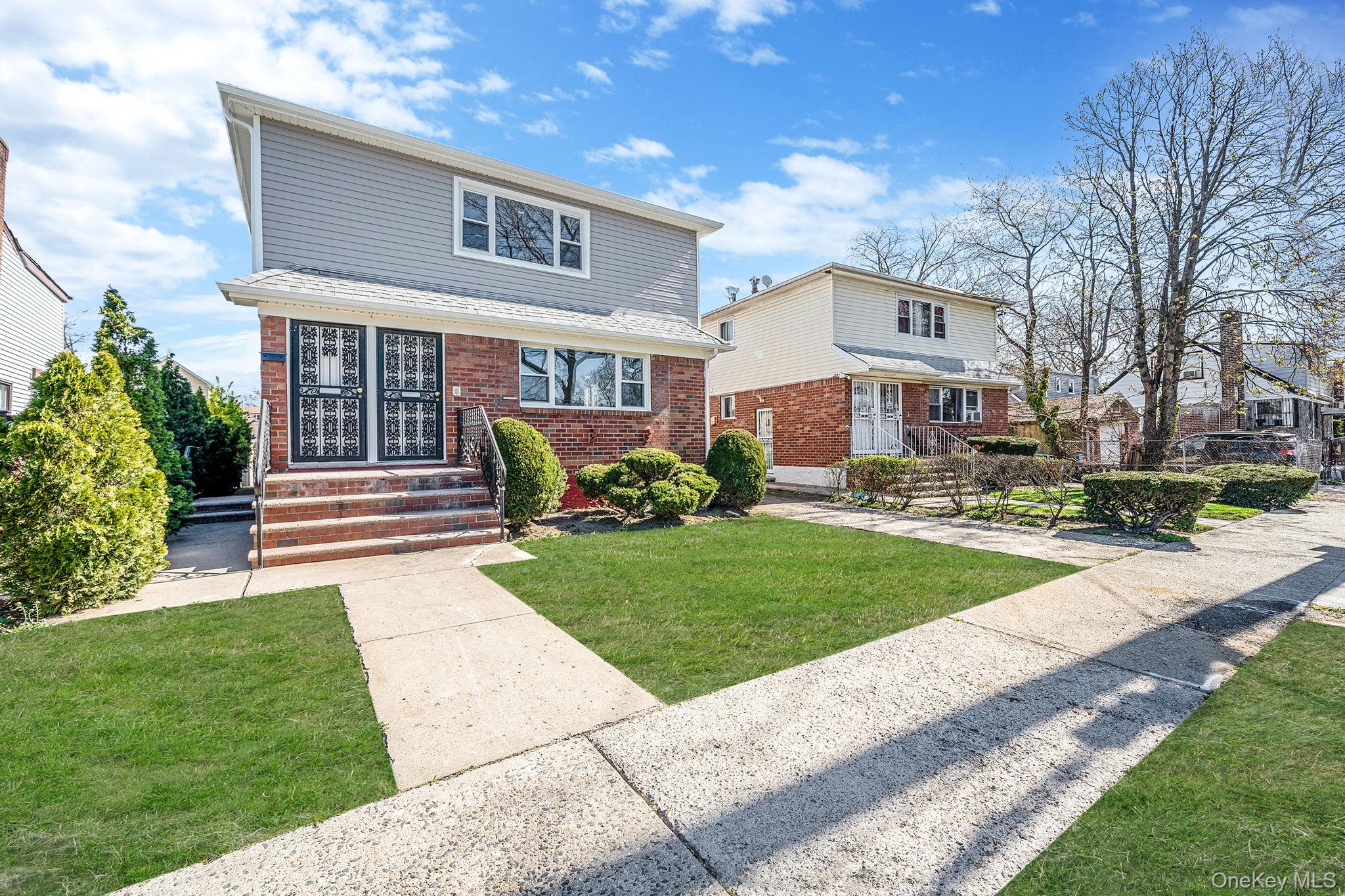 220-53 137th Road Queens, NY 11413 - Photo 3 of 41 a front view of a house with garden