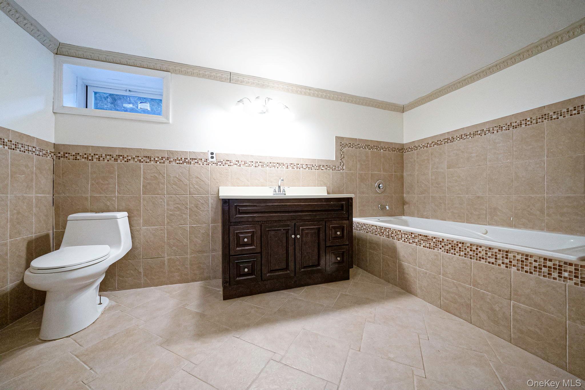 220-53 137th Road Queens, NY 11413 - Photo 33 of 41 a bathroom with a granite countertop toilet sink and mirror