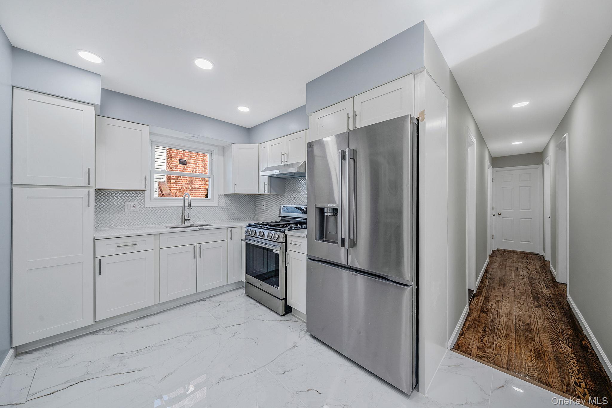 220-53 137th Road Queens, NY 11413 - Photo 7 of 41 a kitchen with a refrigerator sink and stove