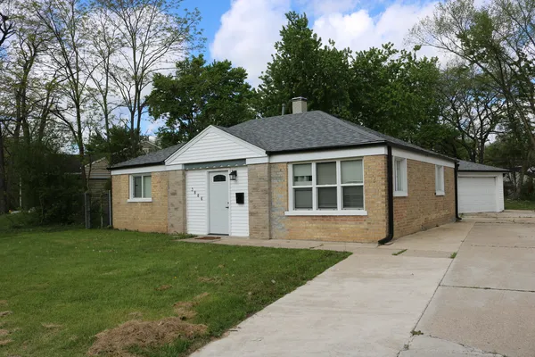 a front view of a house with a garden and yard