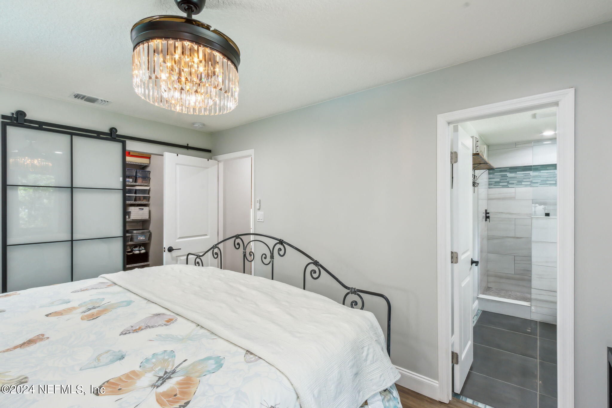 2636 Elbow Road Orange Park, FL 32073 - Photo 19 of 43 a bedroom with a bed and a chandelier