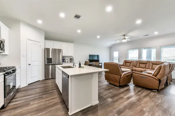 a living room with stainless steel appliances kitchen island furniture and a view of kitchen