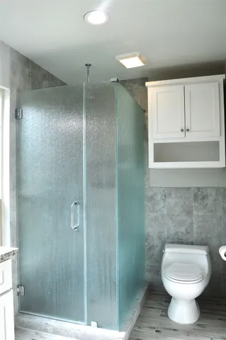 a bathroom with a toilet and a shower