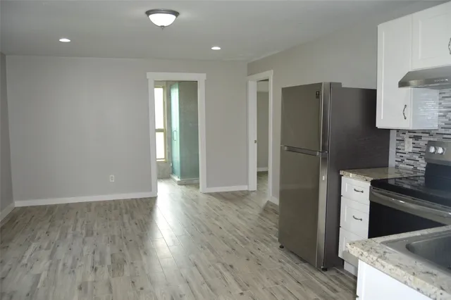 a kitchen with granite countertop stainless steel appliances a refrigerator and a stove