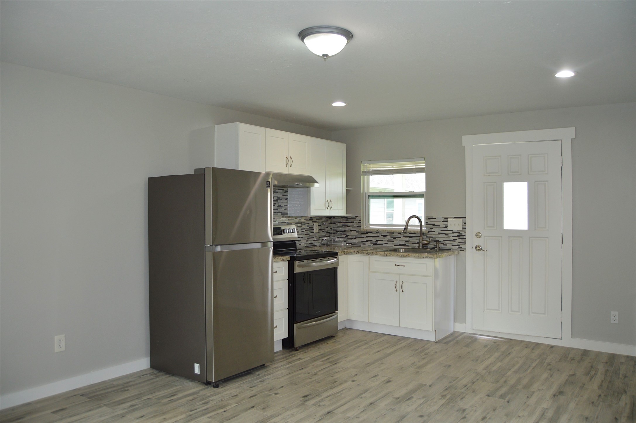 29315 Burton Cemetery Road Waller, TX 77484 - Photo 6 of 22 a kitchen with granite countertop a refrigerator and a stove top oven