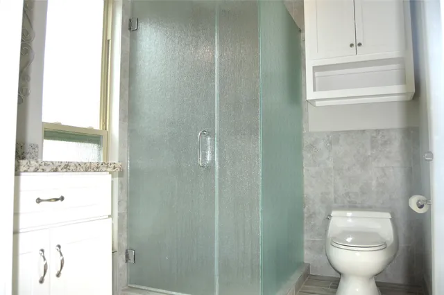 a bathroom with a toilet and a shower