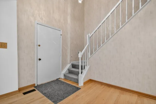 a view of entryway and hall with wooden floor