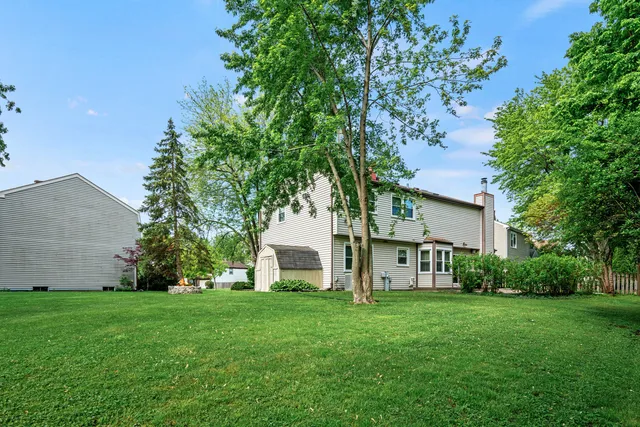 a view of a house with backyard and a tree