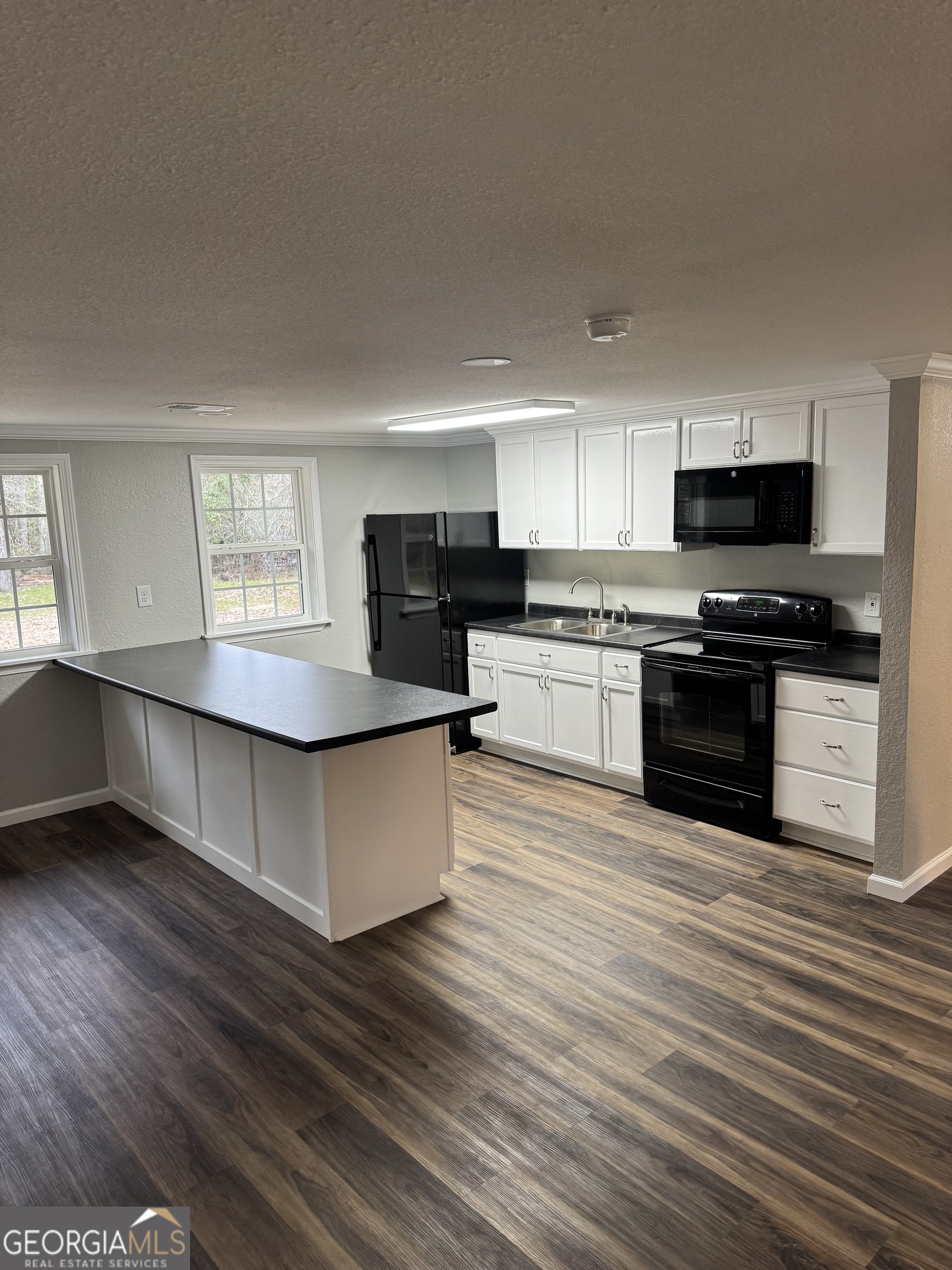 228 Hobbins Drive Dublin, GA 31021 - Photo 9 of 17 a large kitchen with cabinets wooden floor and stainless steel appliances
