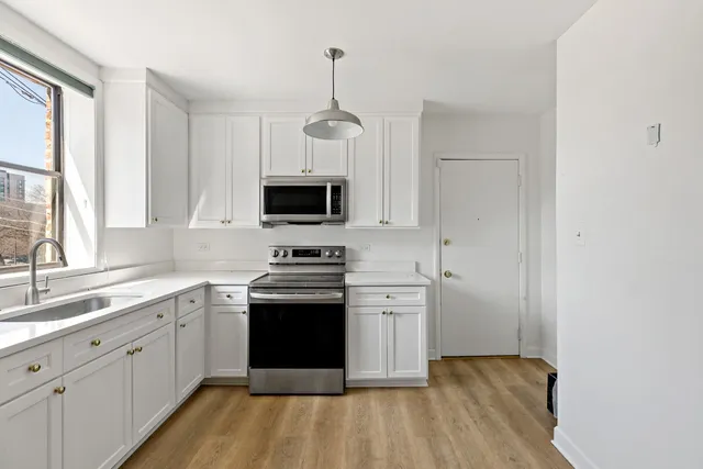 a kitchen with stainless steel appliances a sink stove and microwave