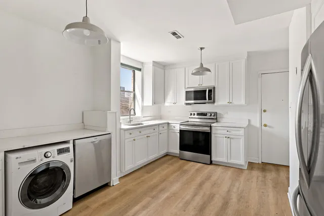 a kitchen with stainless steel appliances granite countertop a stove a sink and a refrigerator