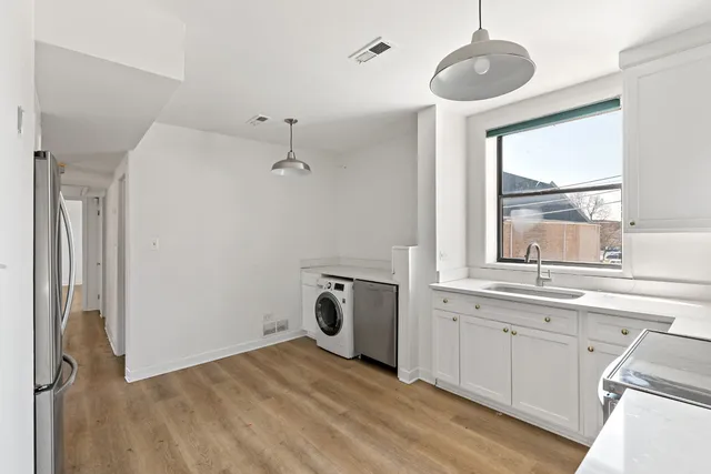 a view of a kitchen with a sink dishwasher and wooden floor