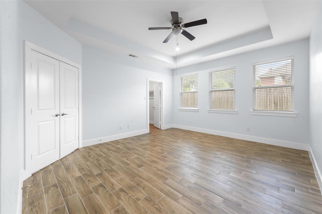 3807 Winding Road Arlington, TX 76016 - Photo 3 of 23 Spacious interior room featuring wood-finish flooring, light-colored walls, a tray ceiling, and a ceiling fan