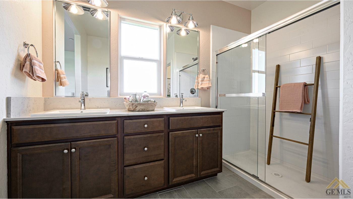 Undisclosed Address Bakersfield, CA 93313 - Photo 13 of 14 a bathroom with a double vanity sink a mirror and a shower