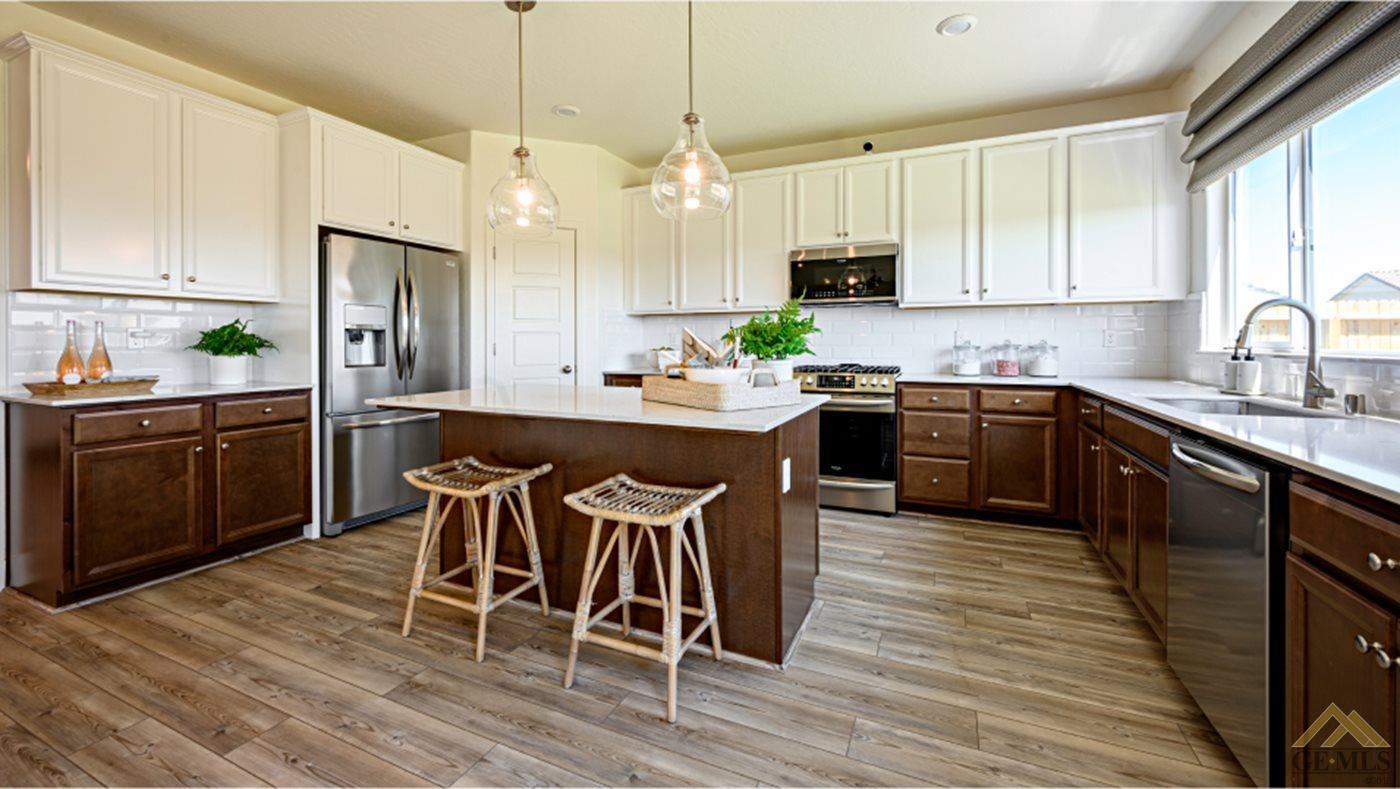 Undisclosed Address Bakersfield, CA 93313 - Photo 3 of 14 a kitchen with stainless steel appliances granite countertop wooden cabinets a sink a stove a dining table and chairs