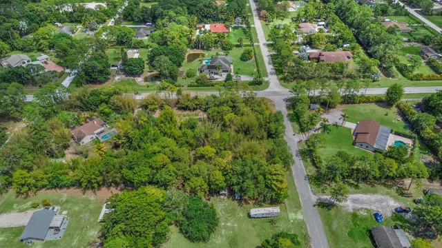 an aerial view of residential house with outdoor space and trees all around