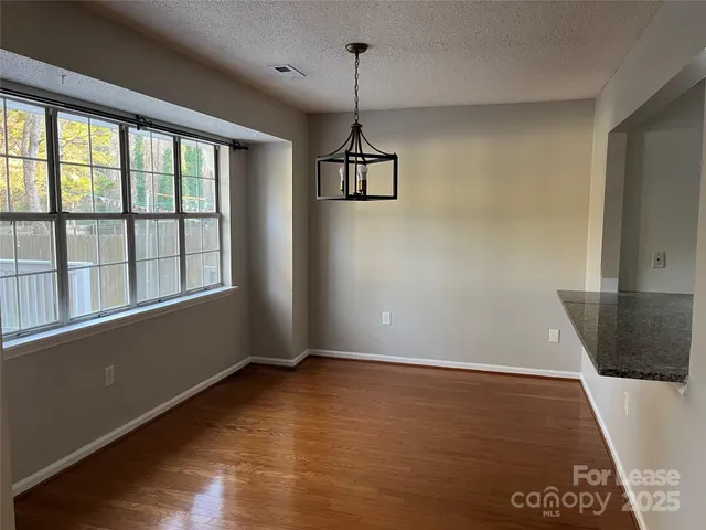 a view of a room with wooden floor and windows