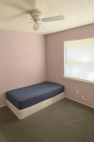 a room with a window and a ceiling fan