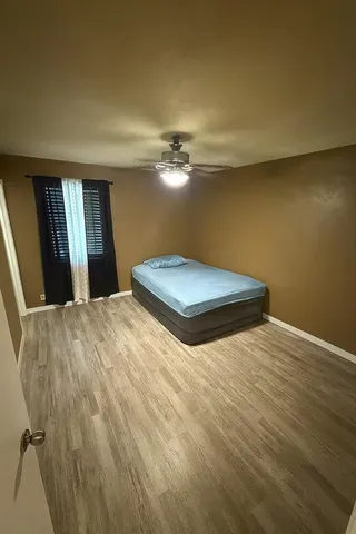 a bedroom with a bed and a ceiling fan