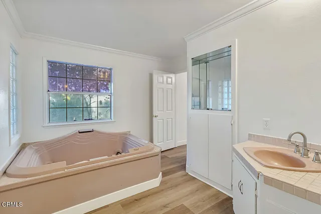 a bathroom with a tub sink and mirror