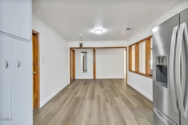 a view of a hallway with wooden floor and a window