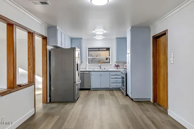 a kitchen with a refrigerator a sink and cabinets