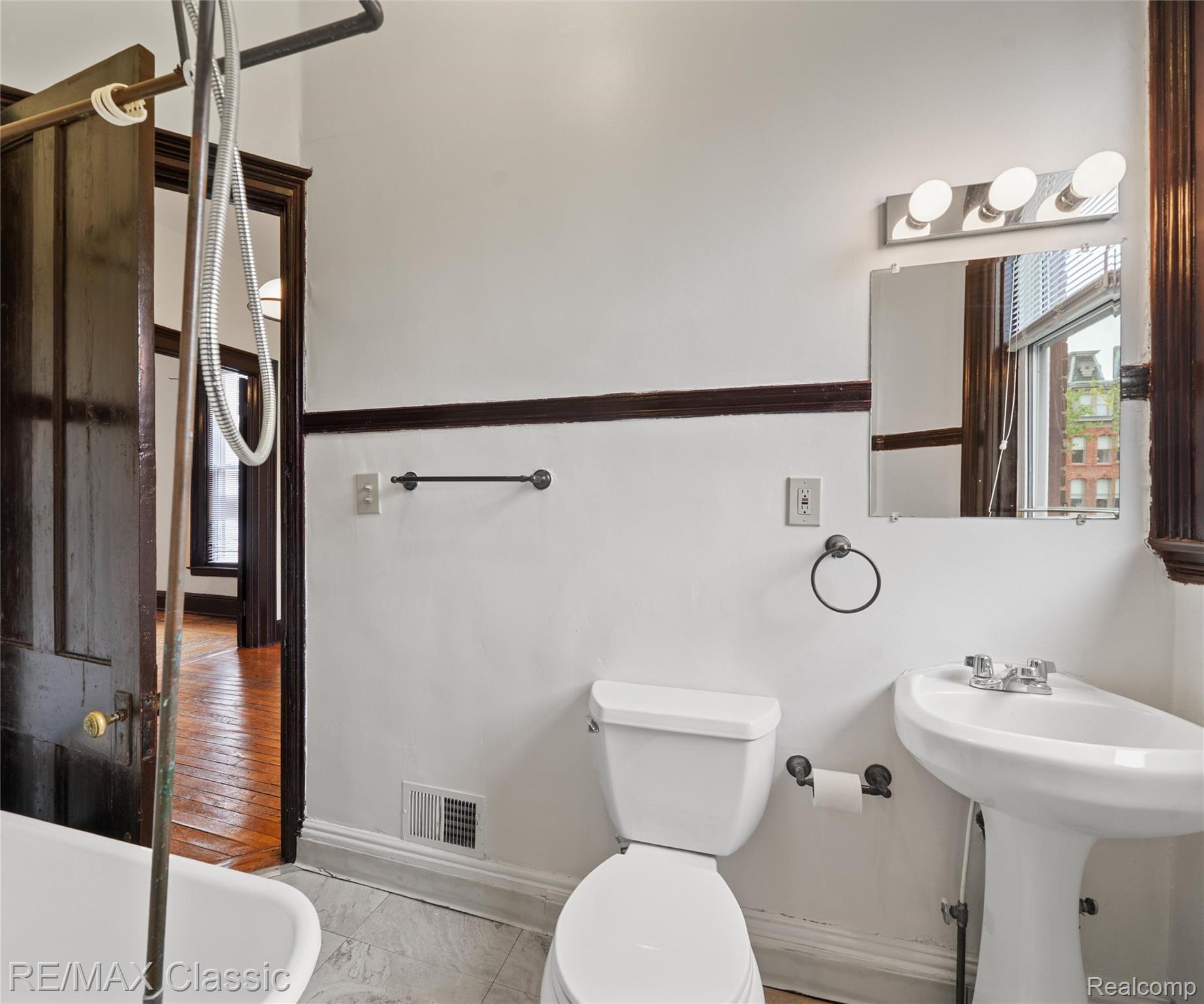 3941 Trumbull Detroit, MI 48208 - Photo 21 of 46 Bathroom featuring a pedestal sink, toilet, and a wall-mounted vanity light