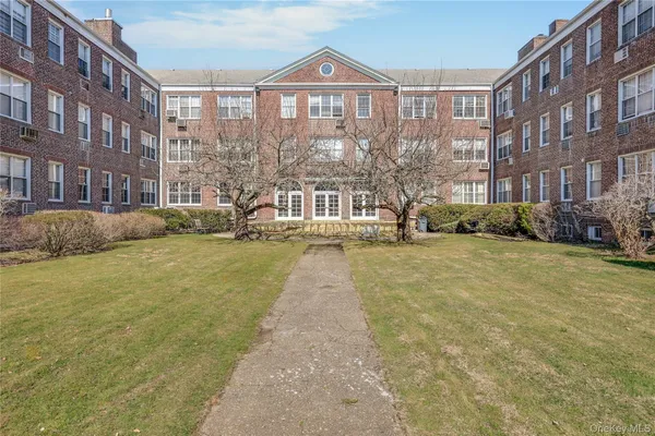 a view of a brick building next to a yard