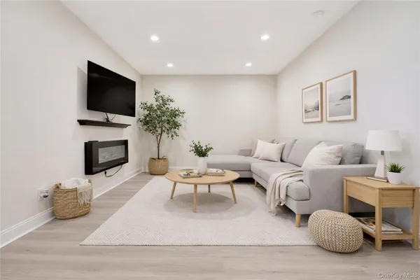 a living room with furniture a flat screen tv and a fireplace