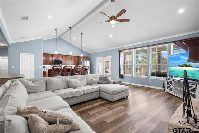 a kitchen with stainless steel appliances kitchen island granite countertop a refrigerator oven a sink with island and chairs