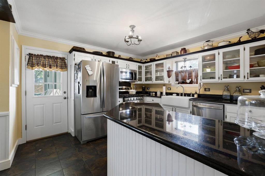 304 East 9th Street Bonham, TX 75418 - Photo 13 of 39 a kitchen with stainless steel appliances granite countertop a refrigerator a stove and a sink with wooden floor