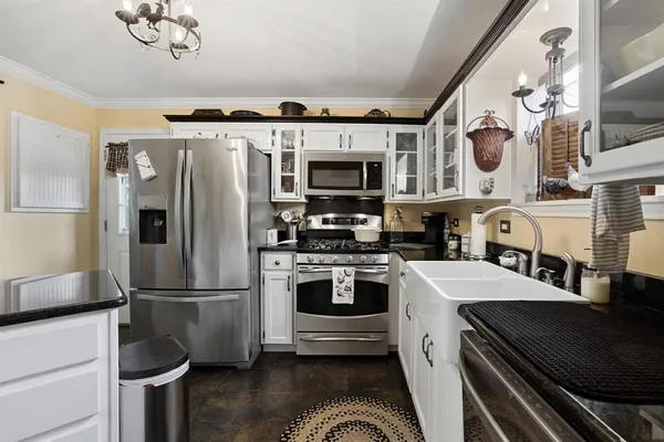 a kitchen with stainless steel appliances granite countertop a refrigerator a stove and a sink with wooden floor