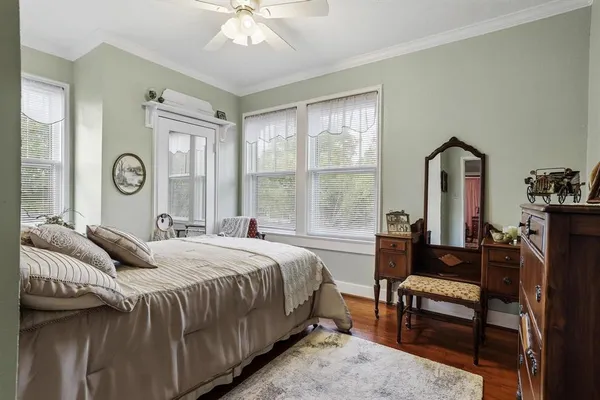 a bedroom with a bed and a dresser next to a window