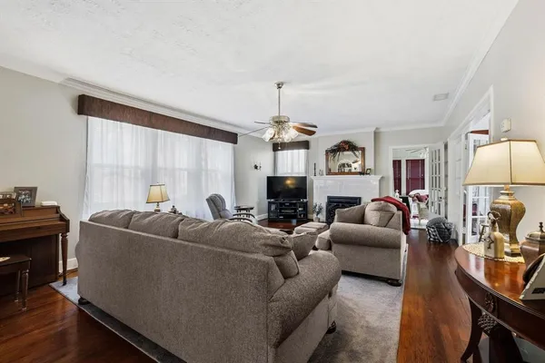 a living room with furniture a fireplace and a chandelier