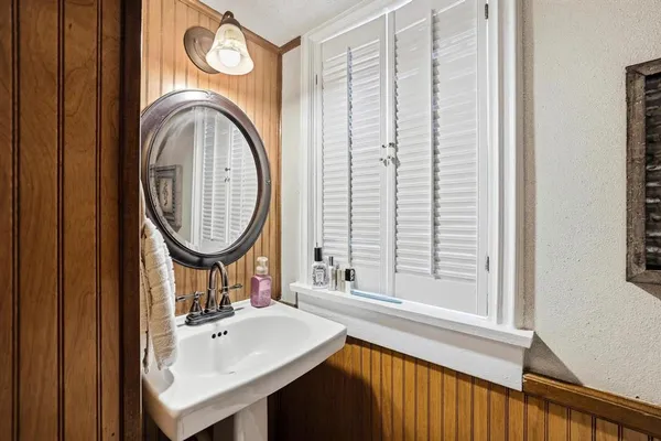 a bathroom with a sink a mirror and a window