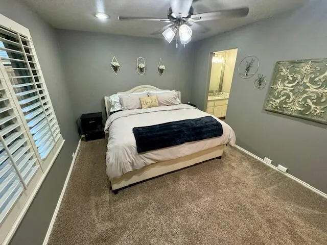 a bedroom with a large bed a flat tv screen and dresser