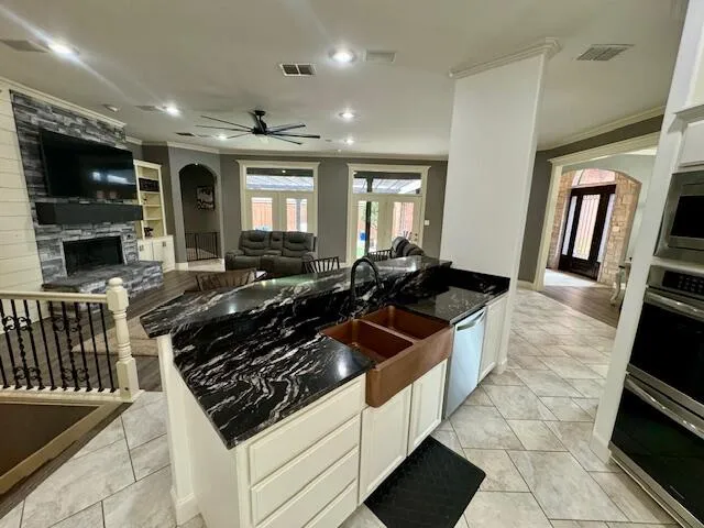 a large kitchen with stainless steel appliances a stove a sink and a microwave