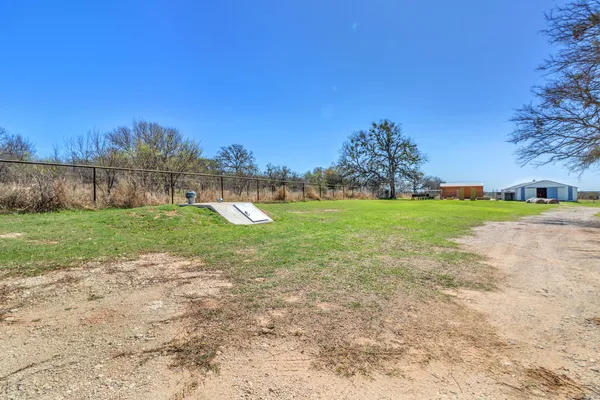 a view of a field with a tree in the background