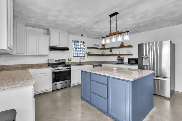a kitchen with stainless steel appliances granite countertop a sink stove and refrigerator