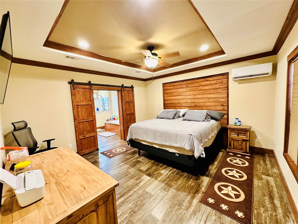 251 County Road 225 Rising Star, TX 76471 - Photo 19 of 40 a bedroom with a bed and wooden floor