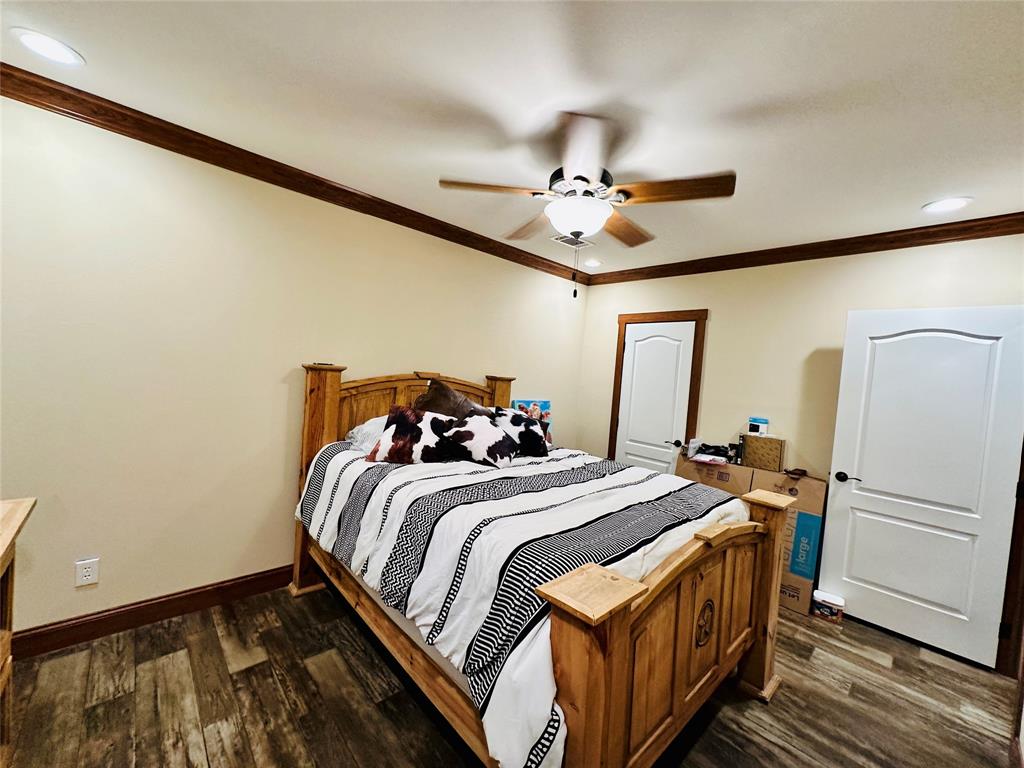 251 County Road 225 Rising Star, TX 76471 - Photo 24 of 40 a bedroom with bed and a chandelier