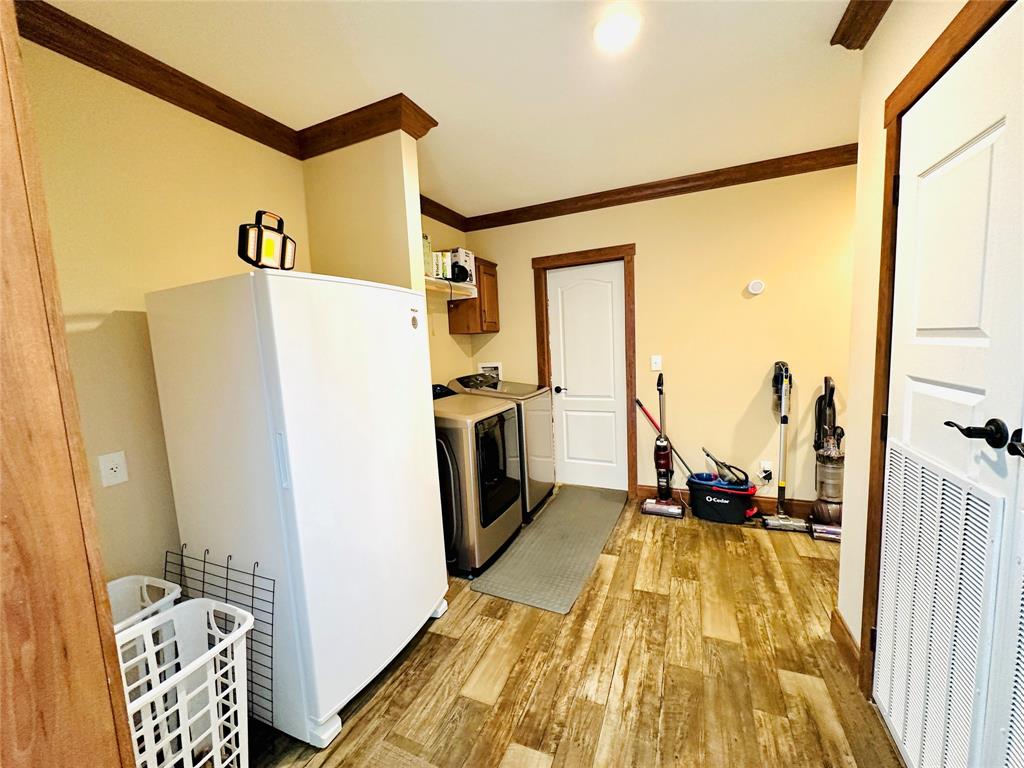 251 County Road 225 Rising Star, TX 76471 - Photo 27 of 40 a view of a kitchen with refrigerator and wooden floor