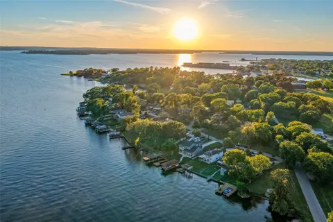 an aerial view of ocean and residential houses with outdoor space