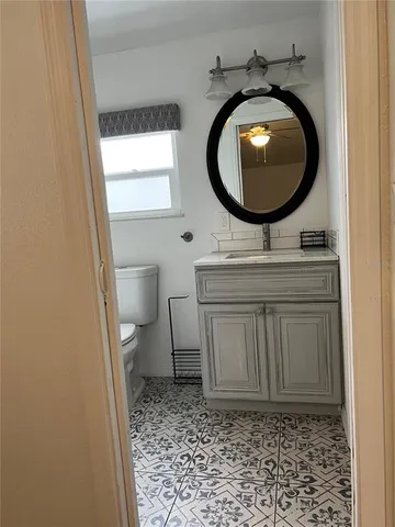a bathroom with a sink a toilet and a mirror