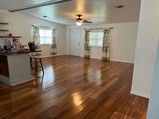 a view of a livingroom with furniture wooden floor and a window
