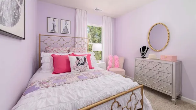 a bedroom with a bed a dresser with wooden floor